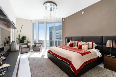 a bedroom with a large bed and a chandelier at Sophisticated Modern Gem with Unreal Ocean Views in Sunny Isles Beach
