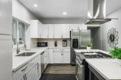 a kitchen with white cabinets and a stove top oven at Luxurious Hollywood Retreat Perfect Getaway in Hollywood