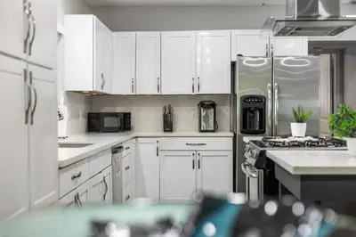 a kitchen with white cabinets and a stainless steel refrigerator at Luxurious Hollywood Retreat Perfect Getaway in Hollywood