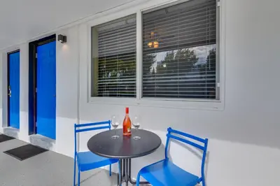 a table with two chairs and a bottle of wine at Pet-Friendly Hallandale Beach Condo Near Boardwalk in Hallandale Beach