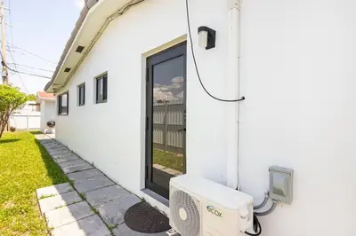 a white house with a tv and a window at Private Double Room Near Miami Clinics in Miami