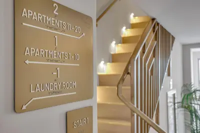 a stairway arrow sign on a wall in a hallway at Vonder Miami Beach - Unit 5 in Miami Beach