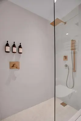 a glass shower stall with three lights on a wall at Vonder Miami Beach - Unit 10 in Miami Beach