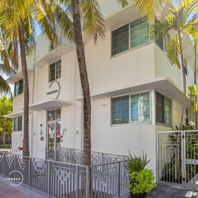 a white building with palm trees in front of it at Vonder Miami Beach - Unit 12 in Miami Beach
