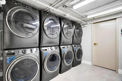 a row of four washing machines in a laundry room at Vonder Miami Beach - Unit 12 in Miami Beach