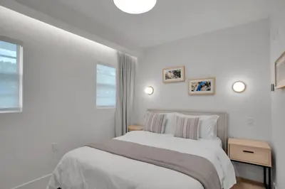 a white bedroom with a bed and two windows at Vonder Miami Beach - Unit 12 in Miami Beach