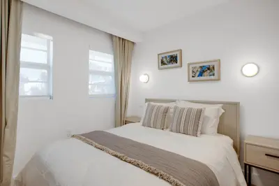 a white bedroom with a bed and two windows at Vonder Miami Beach - Unit 14 in Miami Beach