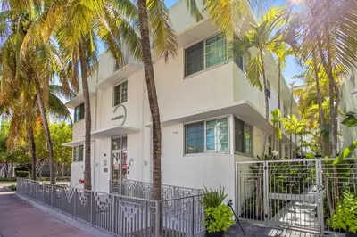 a white building with palm trees in front of it at Vonder Miami Beach - Unit 20 in Miami Beach
