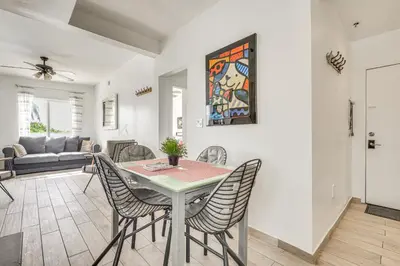 a dining room and living room with a table and chairs at Cozy Miami Beach Apartment Less Than 1 Mi to Ocean! in Miami Beach
