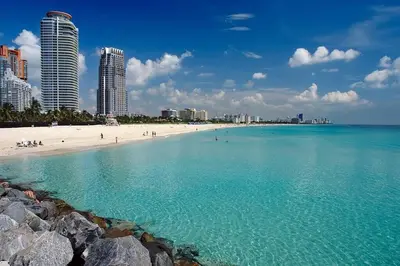 a view of a beach with people and buildings at Miami Beach Home, 7 guests, Steps from the beach in Miami Beach