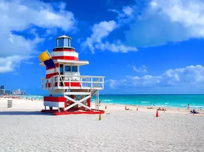 a lighthouse on a beach with people on the beach at Miami Beach Home, 7 guests, Steps from the beach in Miami Beach