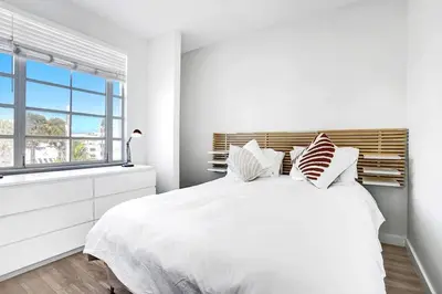 a white bedroom with a large bed and a window at Miami Beach Home, 7 guests, Steps from the beach in Miami Beach