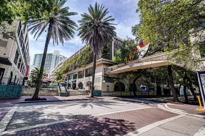 a building with palm trees on a city street at Renovated Coconut Grove Studio includes Parking in Miami