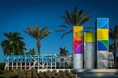 a colorful building with palm trees in the background at Walk to the beach, Studio, Pool AND FREE Parking in Hallandale Beach