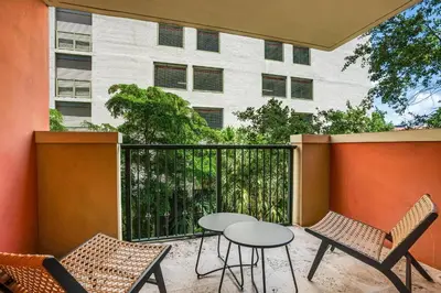 a patio with a table and chairs and a building at The Palms Coconut Grove 1 bedroom condo includes parking in Miami