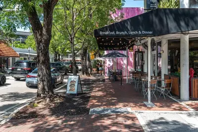 a sidewalk in front of a store with a tree at The Palms Coconut Grove 1 bedroom condo includes parking in Miami
