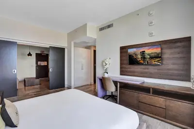 a bedroom with a large bed and a desk at Luxury Beach Front Suite with Rooftop Pool in Hollywood