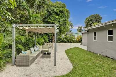 a backyard with a pergola and a couch at Luxury Miami Retreat in North Miami