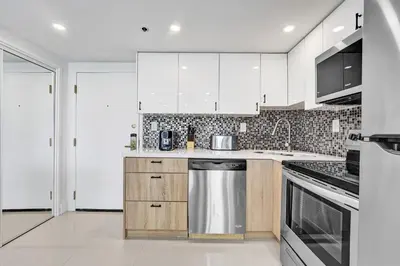 a kitchen with white cabinets and stainless steel appliances at Stunning Ocean View Beach Retreat 1205 in Miami Beach