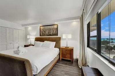 a bedroom with a bed and a large window at Cozy Ocean View Condo Beach Service 617 in Miami Beach