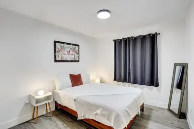 a white bedroom with a bed and a window at Beautiful Home in Maimi in Miami