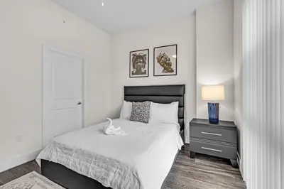 a bedroom with a bed with a white cat on it at Bright and Airy 2 Bed on Biscayne Blvd with Free Park in Miami