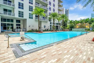 a swimming pool in front of a building at Bright and Airy 2 Bed on Biscayne Blvd with Free Park in Miami