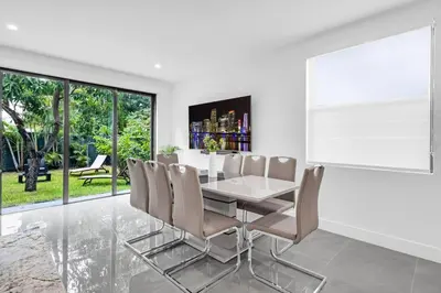 a dining room with a white table and chairs at Paraiso House Pool 10 Ppl 6 mins Coconut Grove in Miami