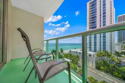 a balcony with chairs and a view of the ocean at Luxe Hollywood Beachfront Condo in Hollywood