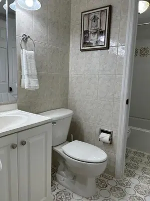a white bathroom with a toilet and a sink at Beautiful apartment with very elegant colonial decoration in Tamiami