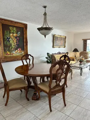 a living room with a table and chairs and a painting at Beautiful apartment with very elegant colonial decoration in Tamiami