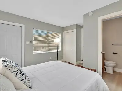 a white bedroom with a bed and a toilet at Coastal Escape, Hollywood Beach Proximity in Hollywood