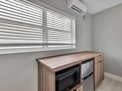 a kitchen with a microwave and a window with blinds at Coastal Escape, Hollywood Beach Proximity in Hollywood