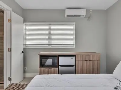 a bedroom with a bed and a tv and a window at Coastal Escape, Hollywood Beach Proximity in Hollywood