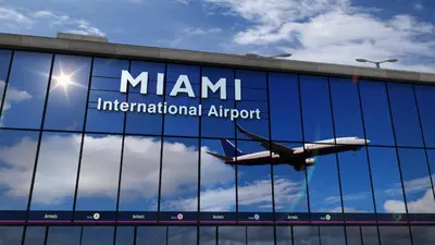 an airplane is flying reflected in the glass of a building at Stylish 3 Bedroom Miami Retreat Close Brickell in Miami