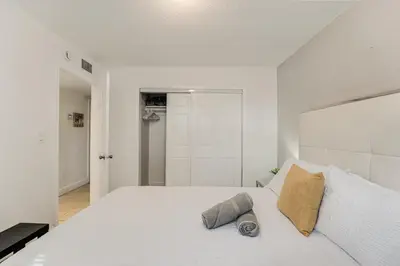 a white bedroom with a large white bed with two pillows at Stylish 3 Bedroom Miami Retreat Close Brickell in Miami