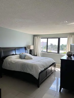a bedroom with a bed and a large window at Beautiful Water View Golden Isles in Hallandale Beach