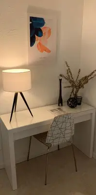 a white desk with a lamp and a potted plant at La Casita in Miami