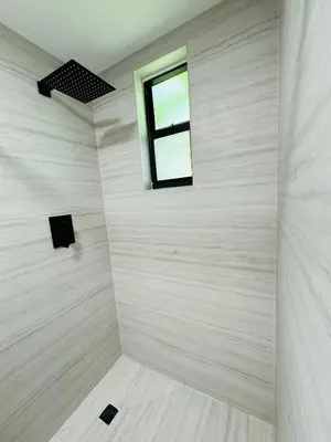 a bathroom with a window and a white wall at La Casita in Miami