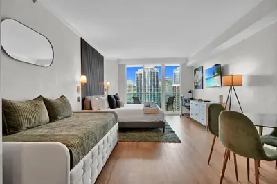 a bedroom with a bed and a desk and a couch at Find Tranquility in the Grove in Miami