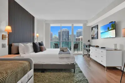 a bedroom with a bed and a desk and a window at Find Tranquility in the Grove in Miami