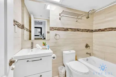 a bathroom with a toilet and a sink and a tub at Beautiful 2 Br Apartment Amazing Pool in Miami Beach