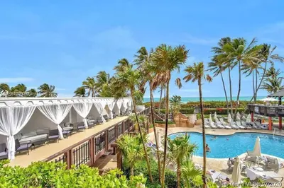 a view of a resort with a pool and palm trees at Beautiful 2 Br Apartment Amazing Pool in Miami Beach