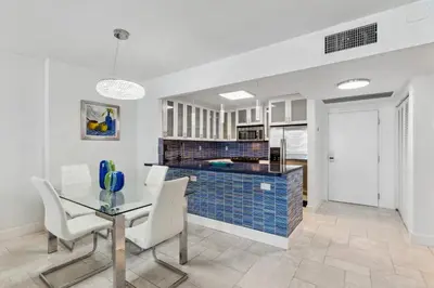 a kitchen and dining room with a table and chairs at Romantic-5 star-1BR-Oceanfront-Balcony-South-Beach in Miami Beach