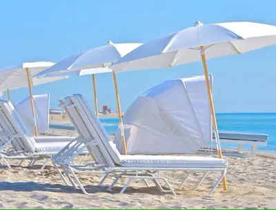 a row of chairs and umbrellas on a beach at Romantic-5 star-1BR-Oceanfront-Balcony-South-Beach in Miami Beach