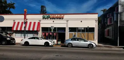 two white cars parked in front of a store at Coco Sol 1 by MyMiamiStay in Miami