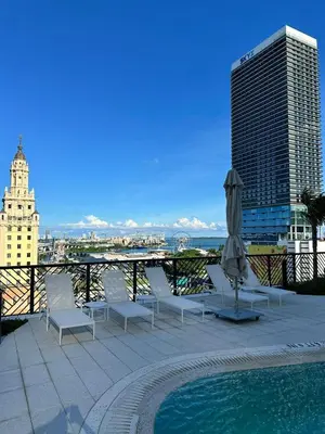 a patio with chairs and an umbrella and a pool at New Luxury Apartment at Downtown Miami in Miami
