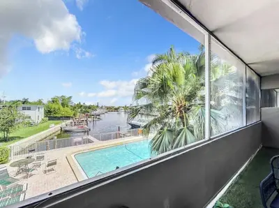 a balcony with a view of a pool and a palm tree at Cordova Arms By Rocketstay in Fort Lauderdale