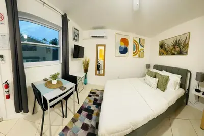 a bedroom with a white bed and a table and a window at Studio with Terrace Near Hard Rock-Patio in Fleetwood Manor