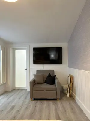 a living room with a couch and a tv on the wall at Cozy Corner in Miami